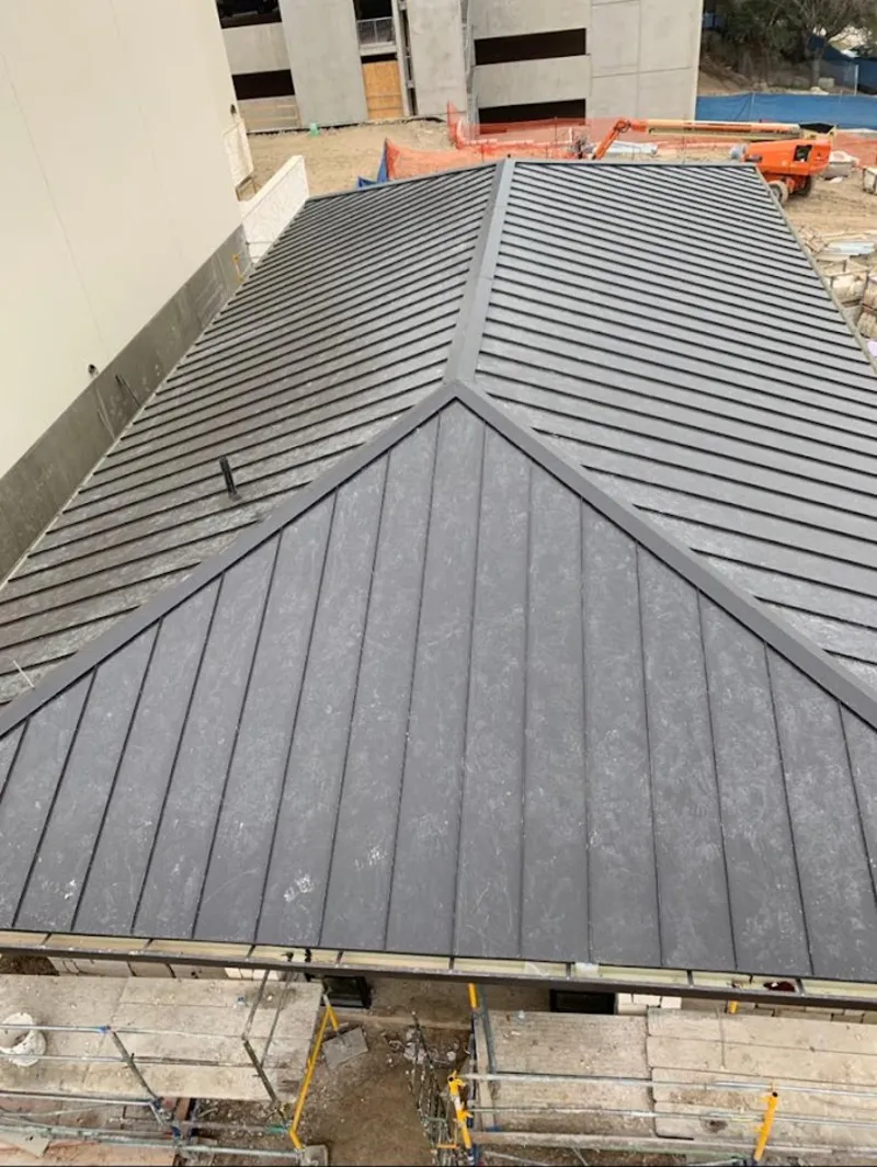 Commercial metal roof construction with crane equipment in St. Louis Park